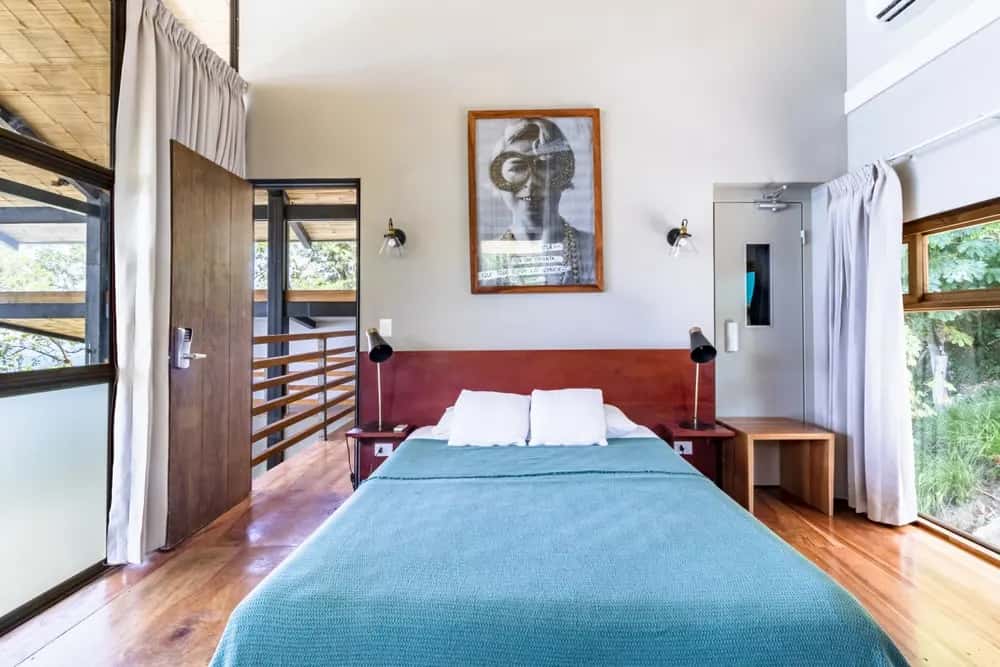 Bedroom with turquoise bedding and balcony doors — Barefoot Chateau 1