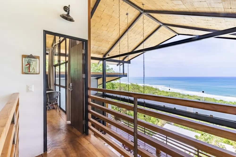 Covered wooden balcony overlooking the ocean — Barefoot Chateau 4