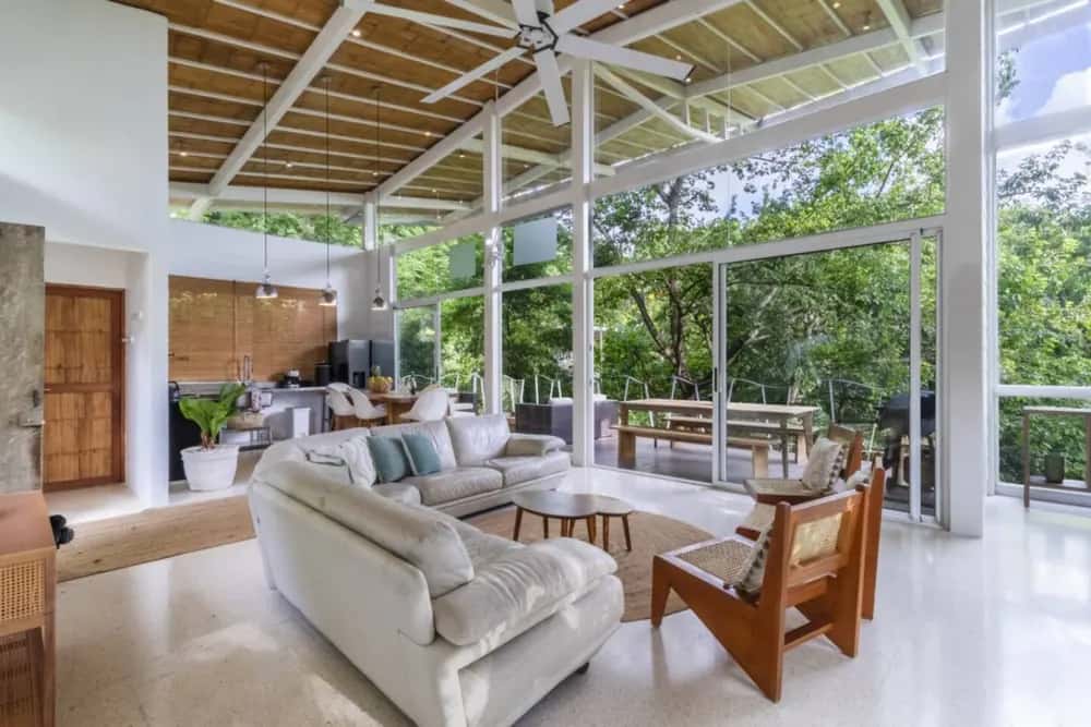 Covered lounge with sofas and tropical garden views — Casa Pochote