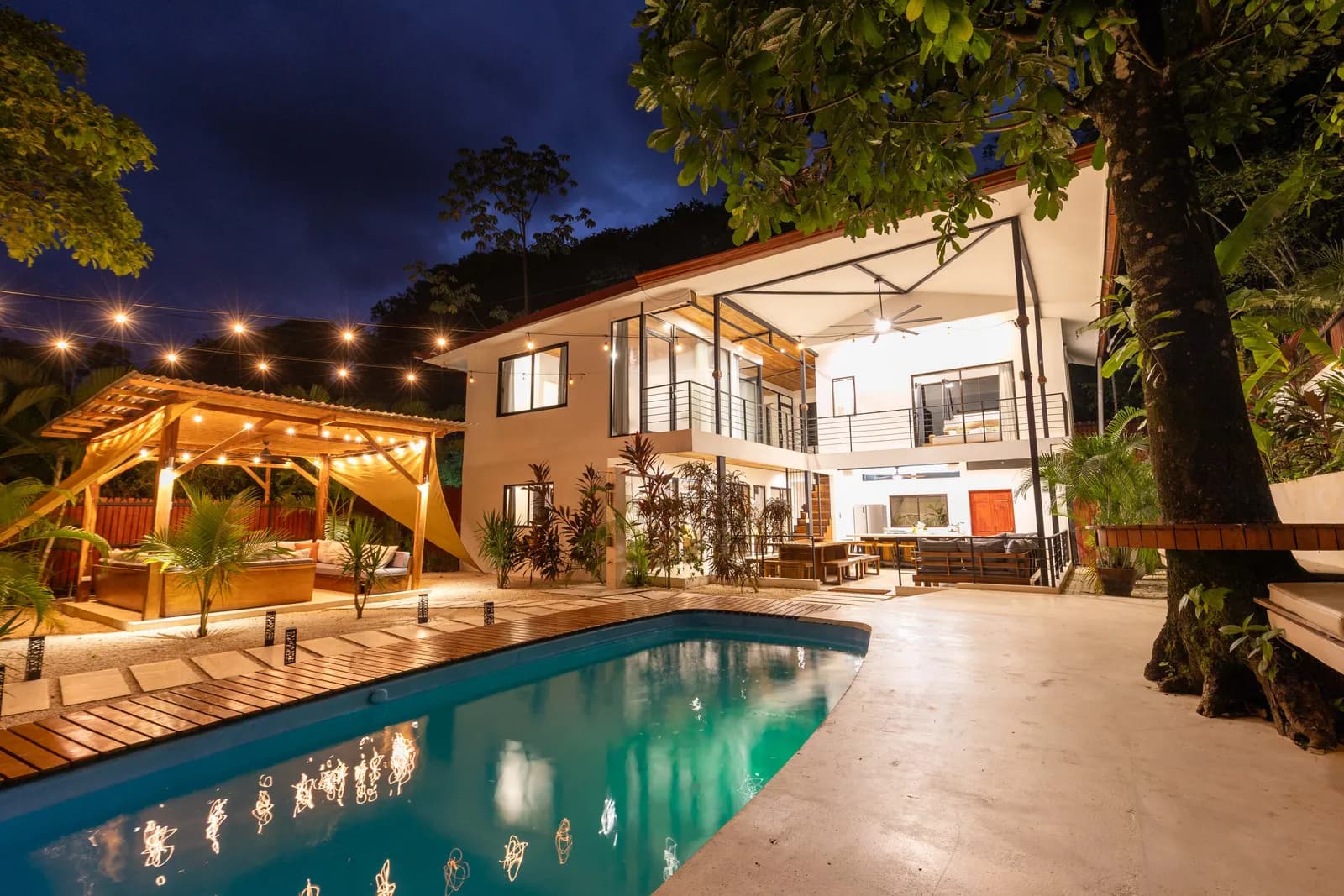 House and pool illuminated at night — Casa Encantada