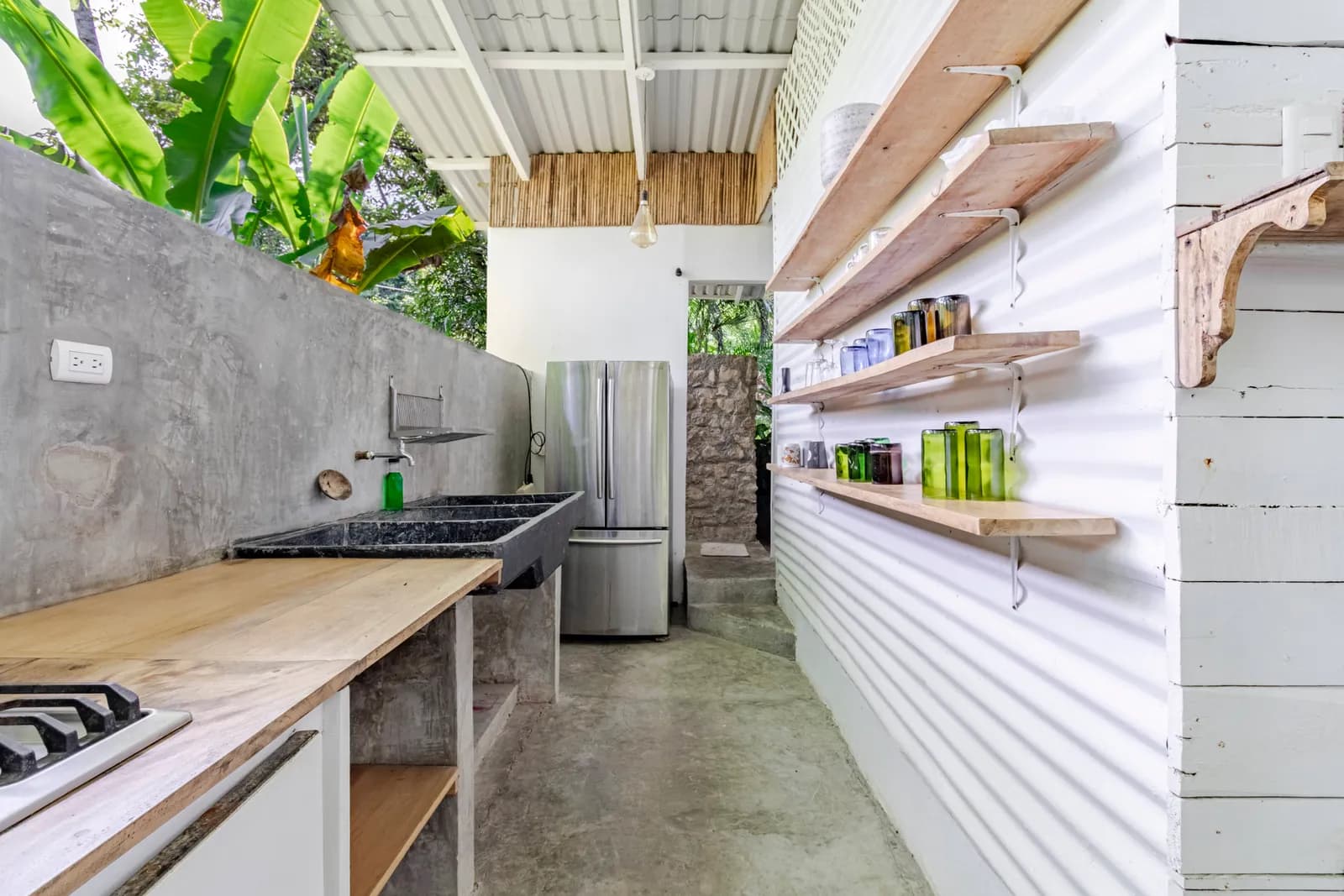 Outdoor kitchen with countertop and refrigerator — Casa Mapachita